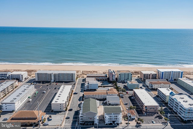 drone / aerial view with a water view, a beach view, and a city view