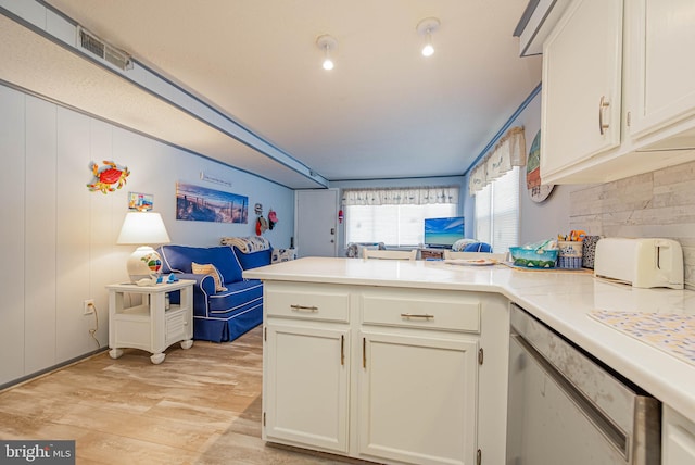 kitchen featuring light wood finished floors, light countertops, decorative backsplash, open floor plan, and a peninsula