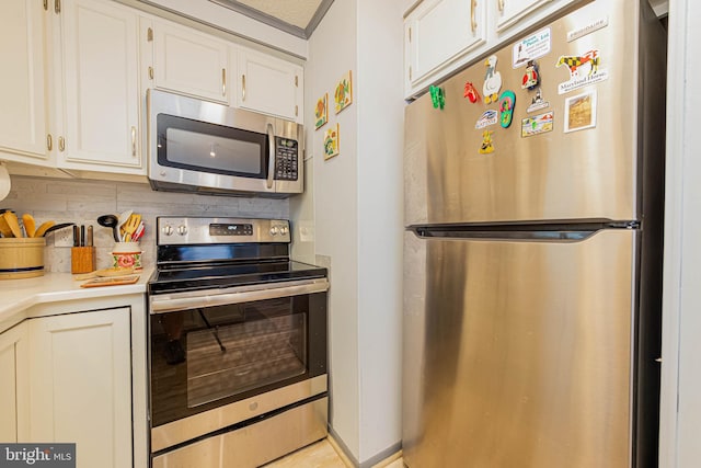 kitchen featuring appliances with stainless steel finishes, tasteful backsplash, light countertops, and white cabinetry