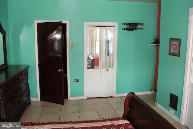 bedroom featuring light tile patterned floors and baseboards