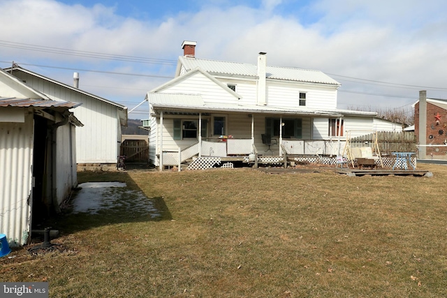 rear view of house with a yard, a porch, and fence