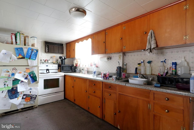 kitchen featuring white appliances, brown cabinets, and a sink