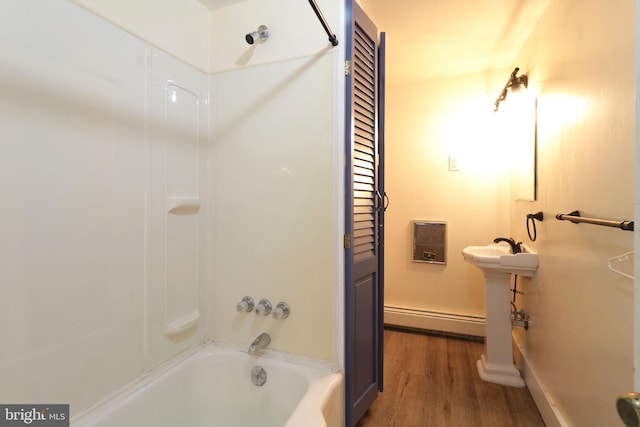 bathroom with a baseboard radiator, baseboards, shower / washtub combination, and wood finished floors