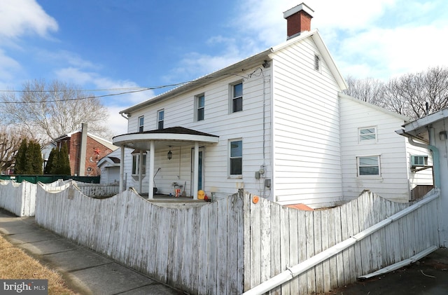 view of front of property featuring a chimney and fence