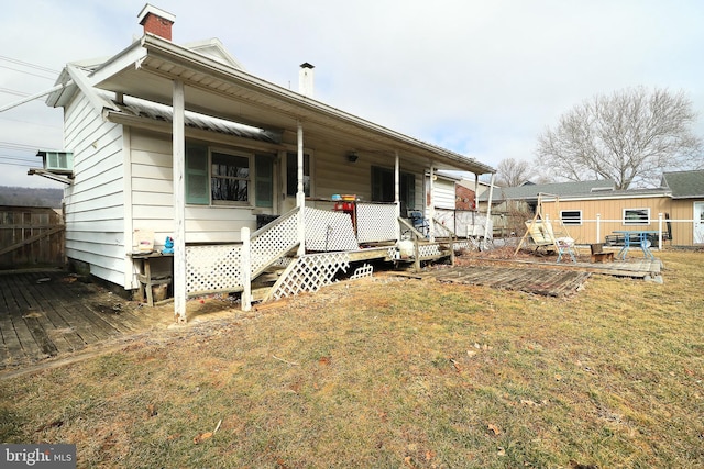 view of front of house with a front yard, fence, and a chimney