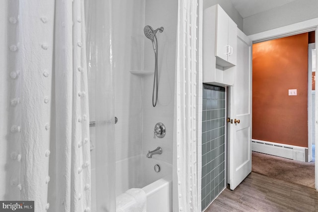 bathroom featuring wood finished floors, baseboard heating, and shower / bath combo with shower curtain