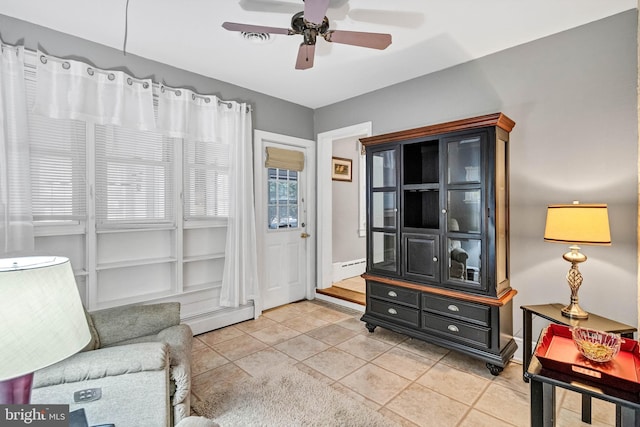 sitting room with a baseboard heating unit, ceiling fan, a baseboard radiator, and light tile patterned flooring