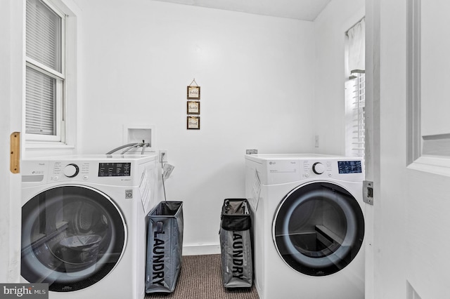 washroom featuring laundry area, separate washer and dryer, carpet floors, and baseboards