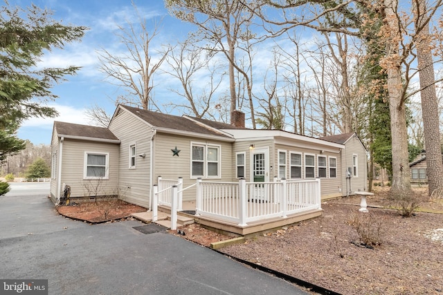 back of house featuring a chimney and a deck