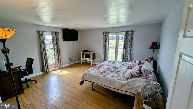 bedroom with baseboards and light wood finished floors