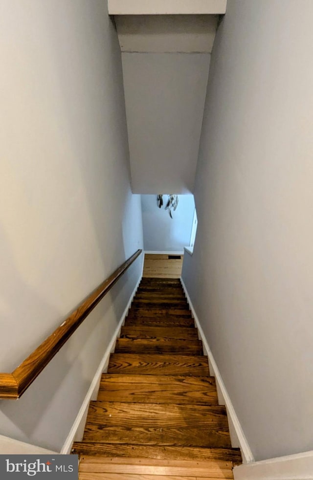 stairs featuring wood finished floors and baseboards