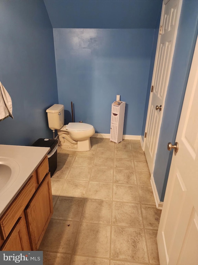 bathroom featuring toilet, vanity, baseboards, and tile patterned floors