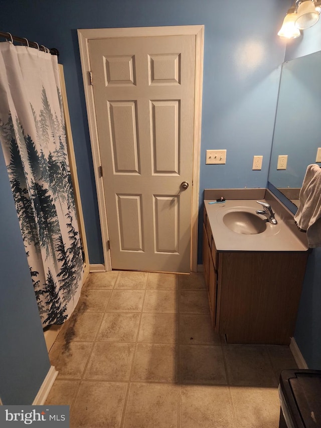 bathroom featuring tile patterned flooring, baseboards, vanity, and a shower with shower curtain