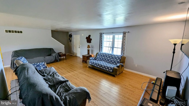 living area featuring wood finished floors, visible vents, and baseboards