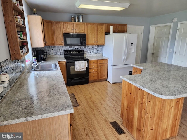 kitchen with visible vents, a sink, light countertops, black appliances, and backsplash