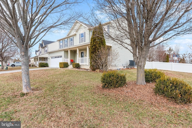 traditional home featuring central air condition unit, covered porch, concrete driveway, a front yard, and fence