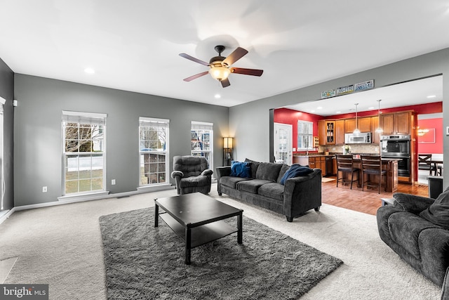 living area featuring recessed lighting, baseboards, ceiling fan, and light colored carpet