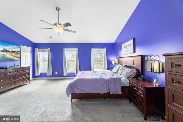 carpeted bedroom featuring baseboards, visible vents, vaulted ceiling, and a ceiling fan