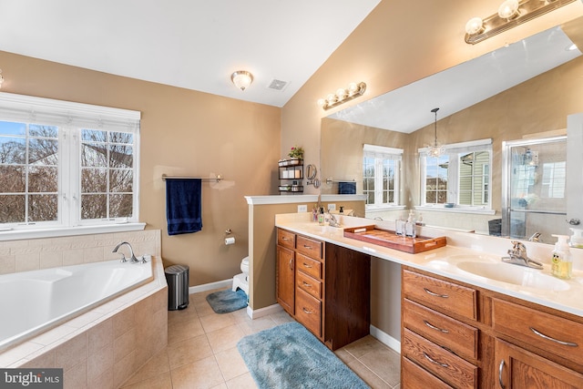 bathroom featuring double vanity, toilet, vaulted ceiling, a sink, and tile patterned floors