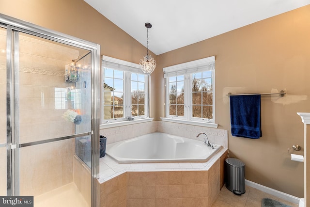 full bathroom featuring tile patterned flooring, baseboards, vaulted ceiling, a bath, and a stall shower