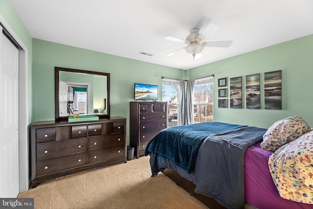 bedroom featuring a closet, carpet, visible vents, and a ceiling fan