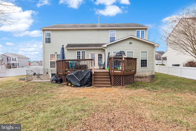 rear view of house featuring a fenced backyard, a wooden deck, and a yard