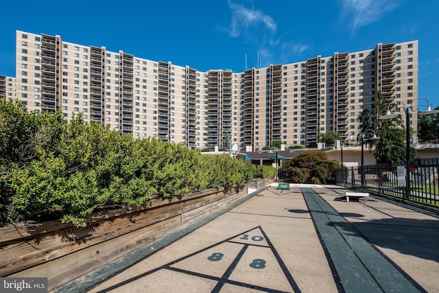 view of property's community with shuffleboard and fence