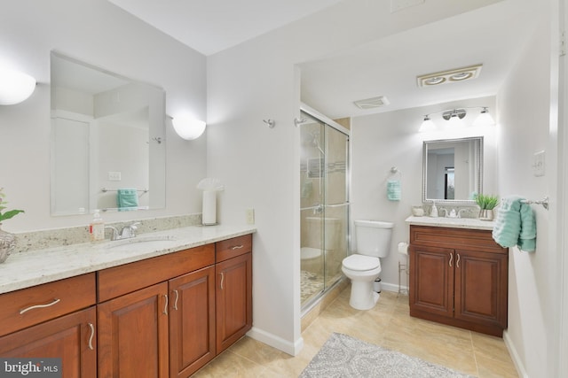 bathroom with toilet, a sink, visible vents, and a shower stall