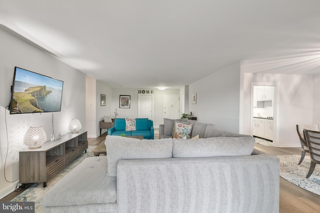 living area featuring baseboards and wood finished floors