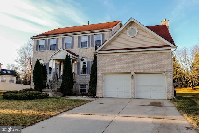 view of front of house with brick siding, concrete driveway, a chimney, an attached garage, and a front yard