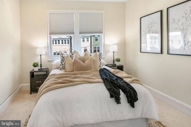 bedroom featuring light carpet and baseboards