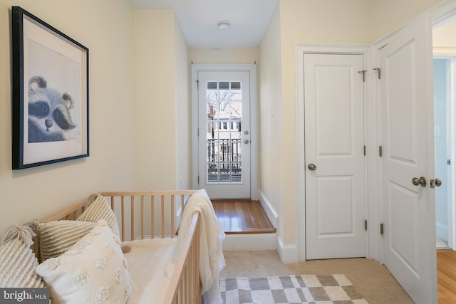 bedroom with access to exterior, light carpet, and baseboards