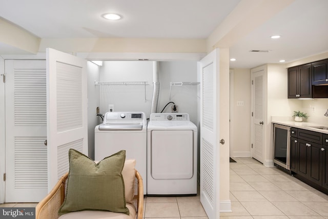 laundry room featuring light tile patterned flooring, recessed lighting, beverage cooler, laundry area, and independent washer and dryer