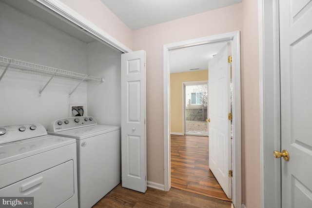 laundry area with laundry area, baseboards, washer and clothes dryer, and dark wood-type flooring