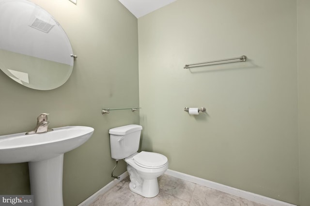 bathroom with tile patterned flooring, baseboards, a sink, and toilet