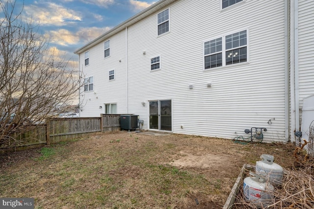 rear view of house with central air condition unit and fence