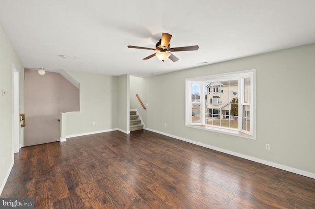 interior space featuring visible vents, baseboards, a ceiling fan, wood finished floors, and stairs