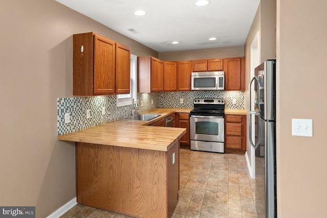 kitchen with backsplash, visible vents, stainless steel appliances, and a sink