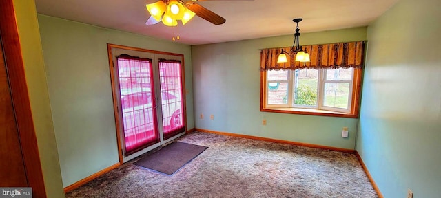 interior space featuring carpet, baseboards, and ceiling fan with notable chandelier