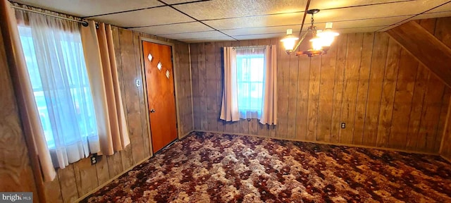 interior space featuring wood walls and an inviting chandelier