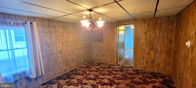 spare room featuring wooden walls and a drop ceiling