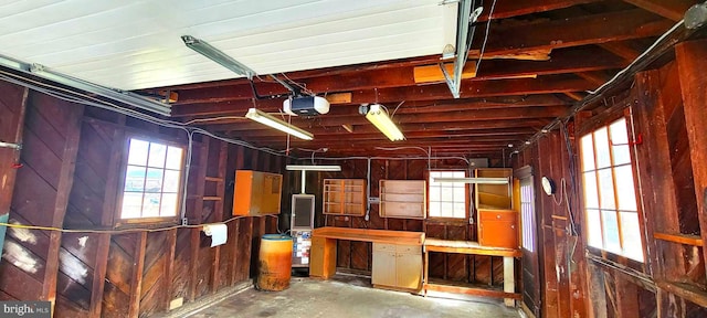 garage with a garage door opener and wooden walls