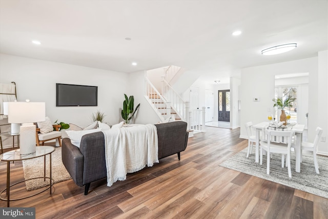 living room with recessed lighting, stairs, baseboards, and wood finished floors