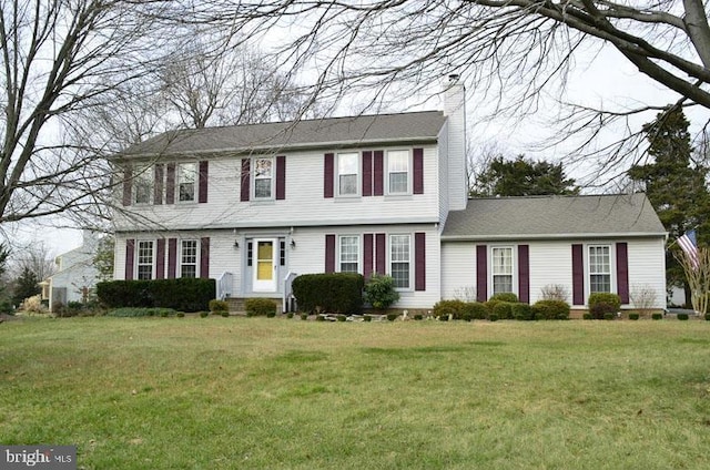 colonial-style house with a front yard and a chimney