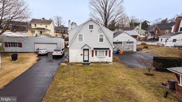 view of front of house with a gambrel roof, a front yard, fence, a garage, and a residential view