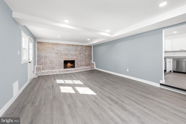 unfurnished living room with a fireplace, baseboards, wood finished floors, and recessed lighting