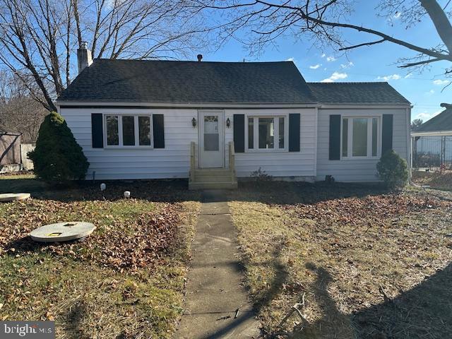 single story home featuring entry steps, roof with shingles, and a chimney