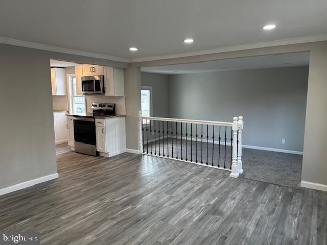 kitchen with stainless steel appliances, open floor plan, ornamental molding, and baseboards