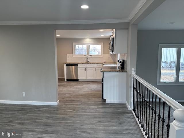 kitchen featuring baseboards, white cabinets, dark wood finished floors, ornamental molding, and stainless steel appliances