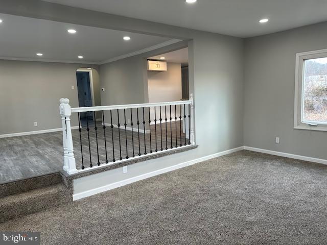 empty room with ornamental molding, baseboards, arched walkways, and recessed lighting